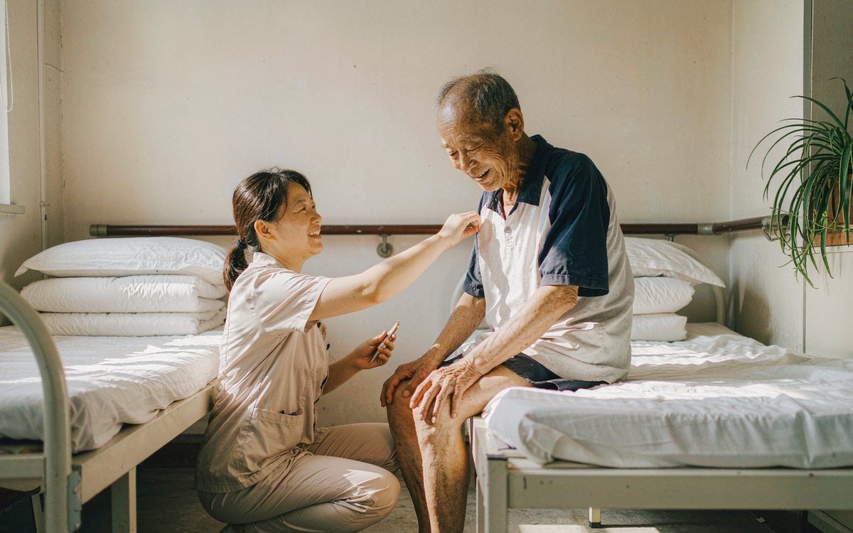 机构场景：护理员与坐在床边的长者交流